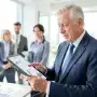 An older professional reviewing financial data in a modern office, symbolizing the experience and economic contribution of the aging workforce.
