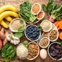 Colorful flatlay of forgotten superfoods including bananas, spinach, lentils, blueberries, and eggs on a rustic table